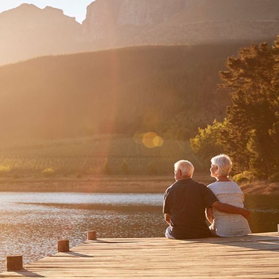 Older couple sitting at the end of a dock