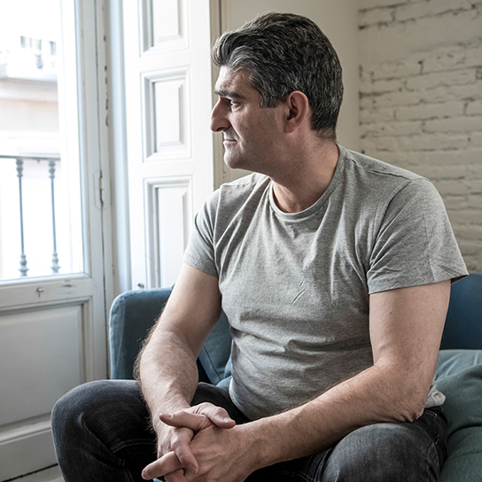 Man sitting on a couch looking out the window