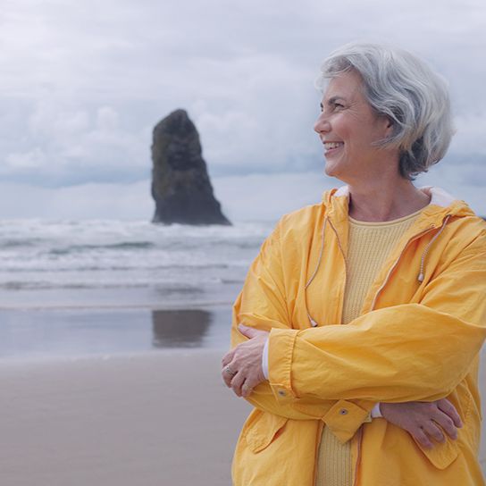 Older woman standing on a beach 