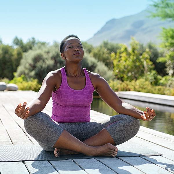 Woman practicing yoga on a dock
